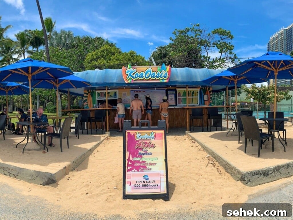 Waikīkī Beach Bar Cocktails with Ocean Views 6 People at the bar Koa Oasis Booze Shack with blue umbrellas and blue sky.