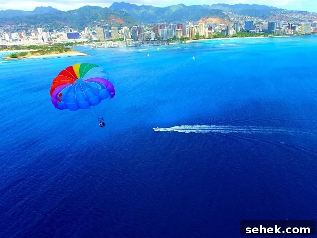 A rainbow parasail sailing off the coast of Waikīkī with a deep blue ocean setting.