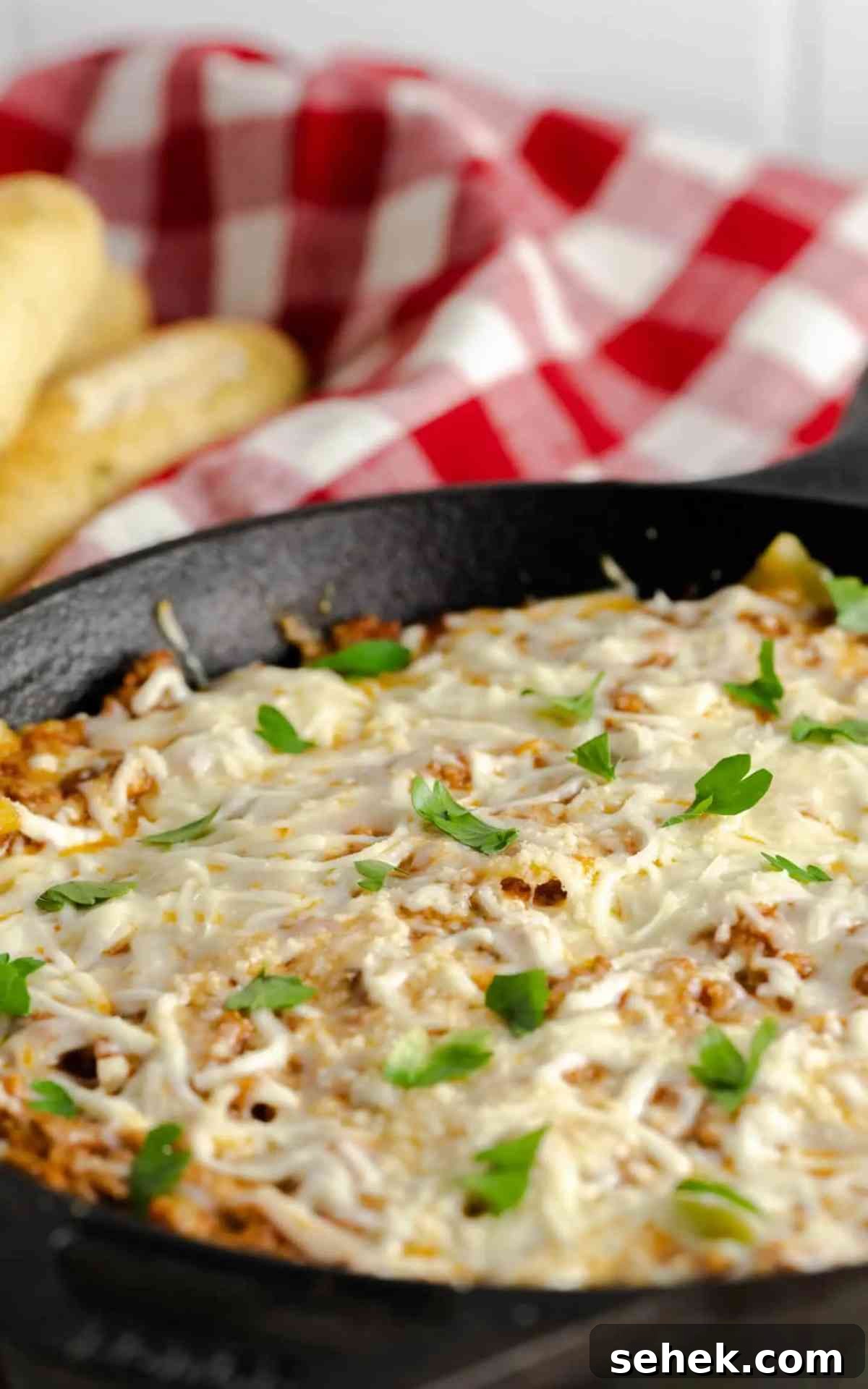 One-Pan Skillet Lasagna: Quick Weeknight Pasta Bake 4 Side view of a cast iron skillet filled with cheesy lasagna.