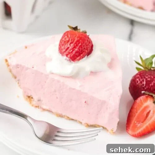 Strawberry Jello pie with a side of slice strawberries on a white plate