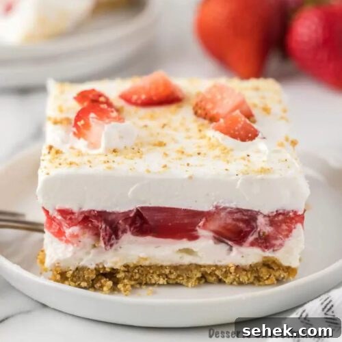 Strawberry Delight cut into squares and served on a white plate.