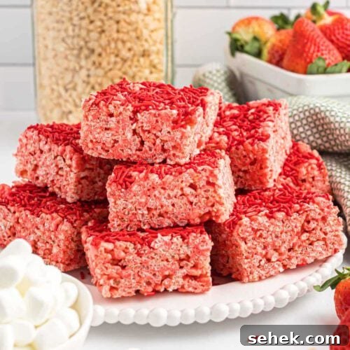 Strawberry Rice Krispie treats cut into bars on a white platter.