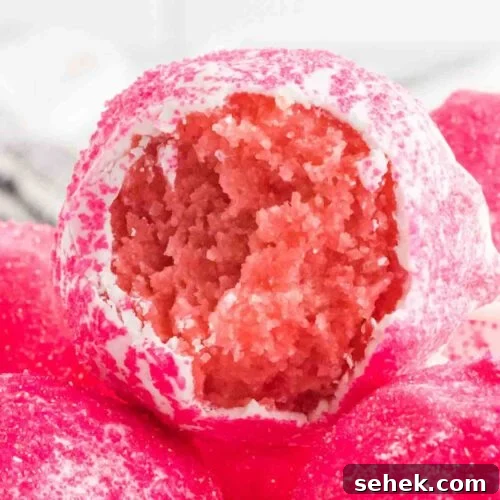 UP close photo of strawberry cake pop with a bite out.