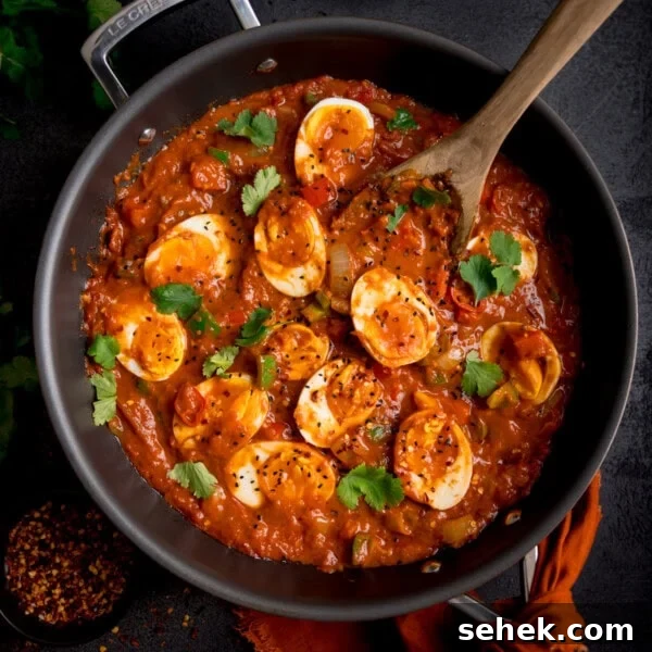 Savory Vegetarian Nut Roast Recipe for Holiday Dinner 8 A frying pan filled with spicy egg curry topped with halved boiled eggs and coriander.