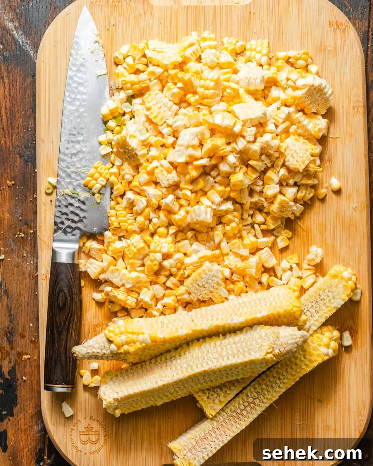 Smoky Blackened Corn with Chili-Lime Butter 4 corn kernels removed from the cob on a cutting board.