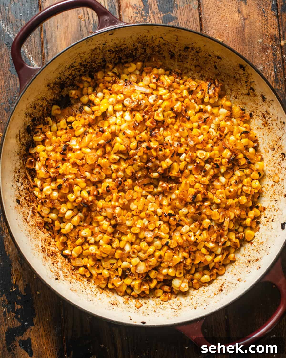 Smoky Blackened Corn with Chili-Lime Butter 5 charred corn in a skillet.