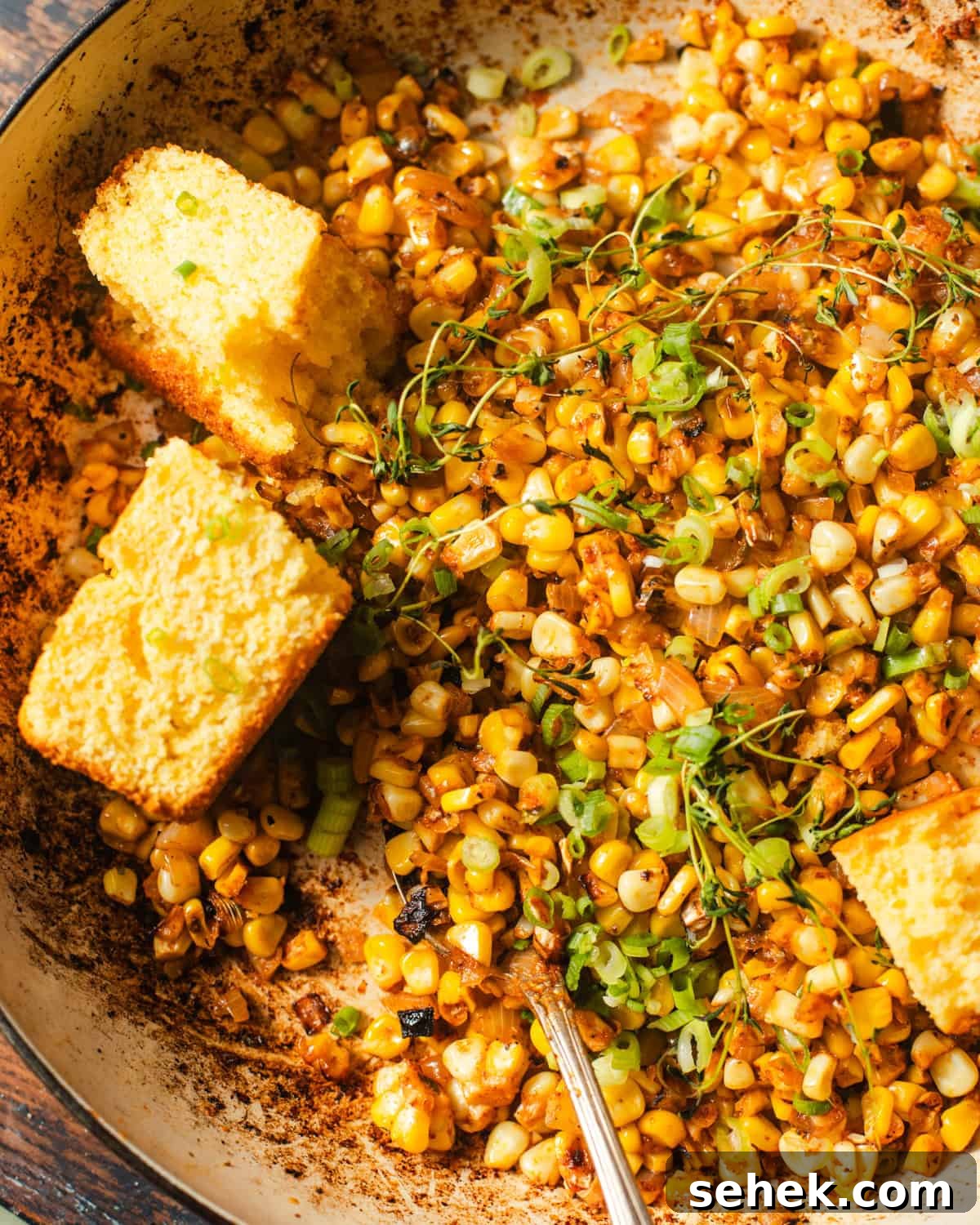 Smoky Blackened Corn with Chili-Lime Butter 6 blackened corn in a skillet with cornbread.