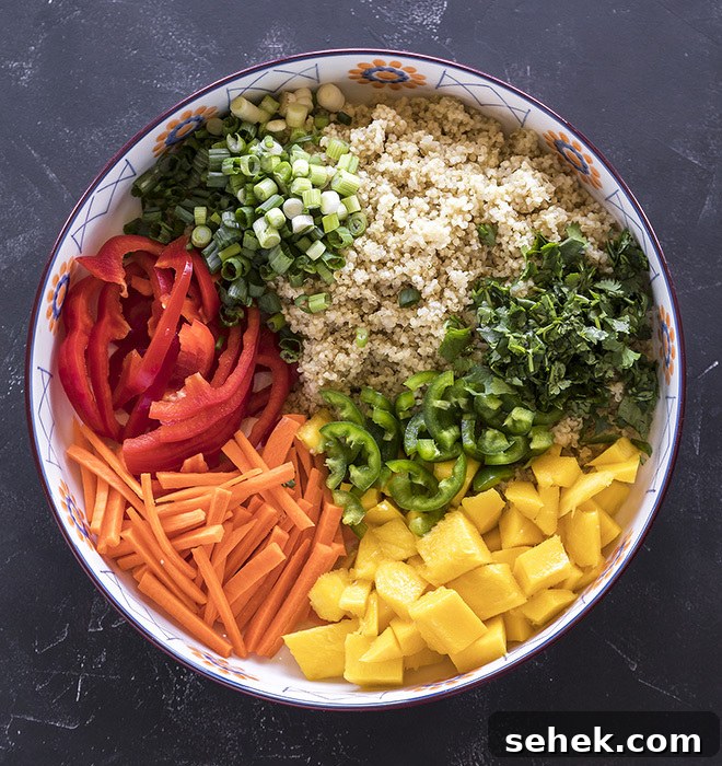 Thai Quinoa Mango Salad with Peanut Ginger Dressing 5 a large bowl with cooked quinoa and chopped red peppers, mango, cilantro, carrots and green onions