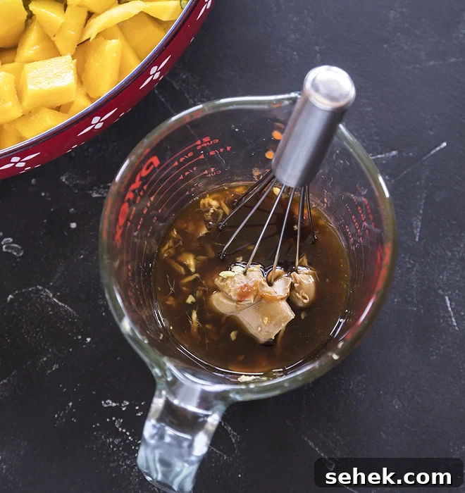 Thai Quinoa Mango Salad with Peanut Ginger Dressing 6 a measuring jar with some added ingredients and a whisk