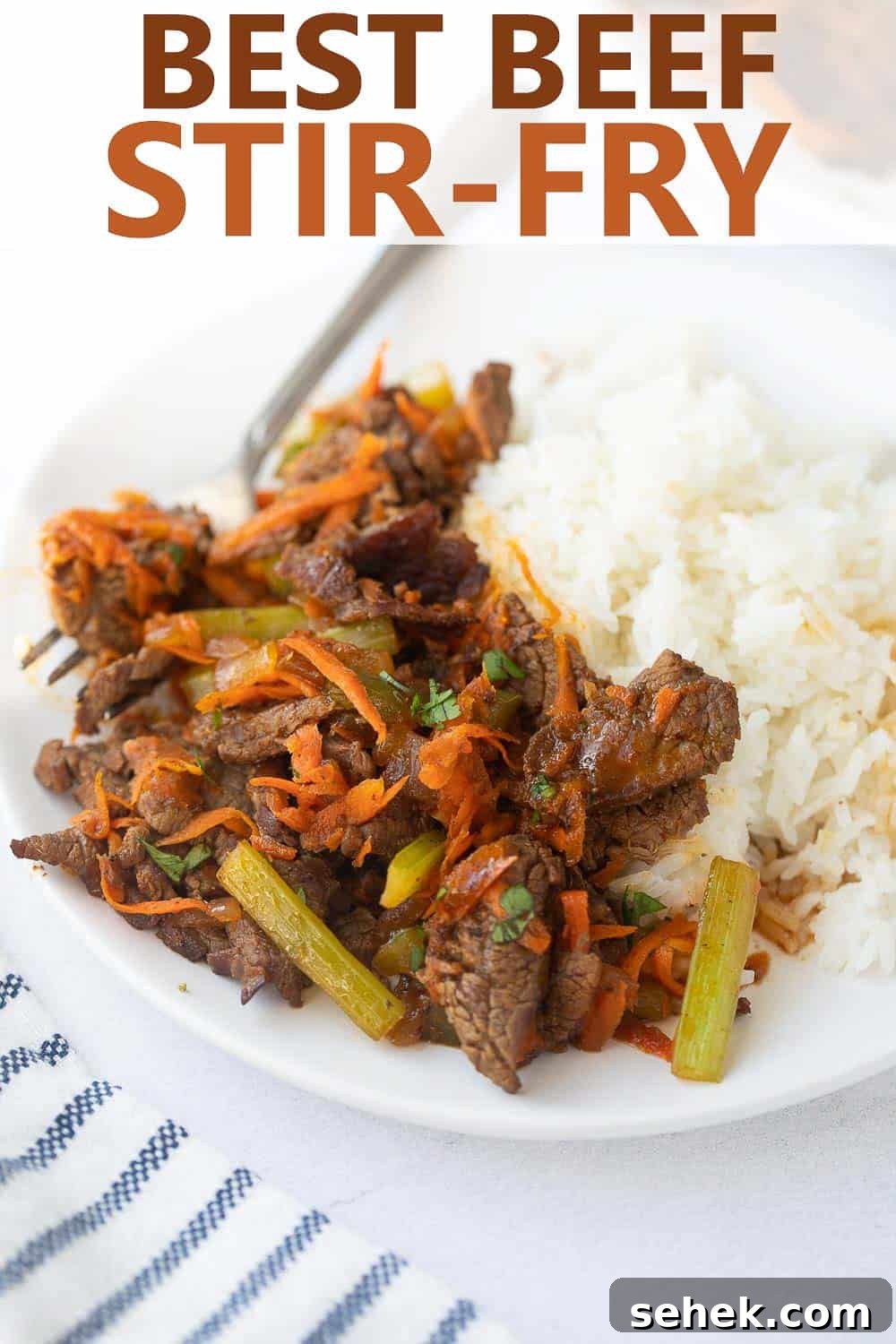 Stir-fry recipe for beef close up shot of beef stir fry and rice on white plate