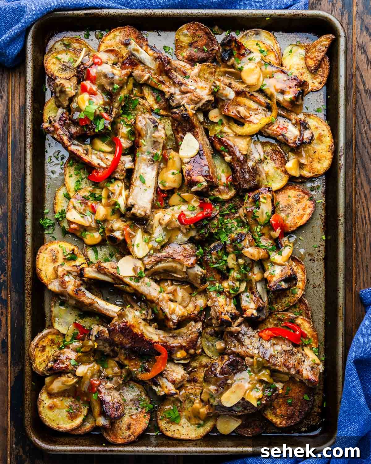 Sticky Glazed Ribs with Crispy Roast Potatoes 2 Sticky ribs with crispy potatoes in large sheet pan with blue napkins.