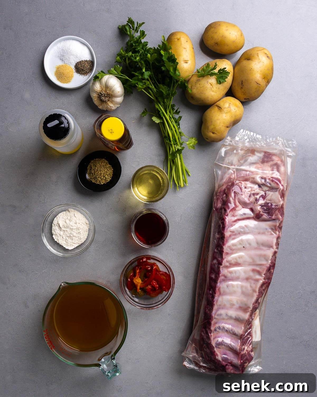 Sticky Glazed Ribs with Crispy Roast Potatoes 4 Ingredients shown: salt, pepper, granulated garlic, garlic, olive oil, honey, oregano, parsley, potatoes, white wine, red wine vinegar, flour, cherry peppers, baby back ribs, and chicken stock.