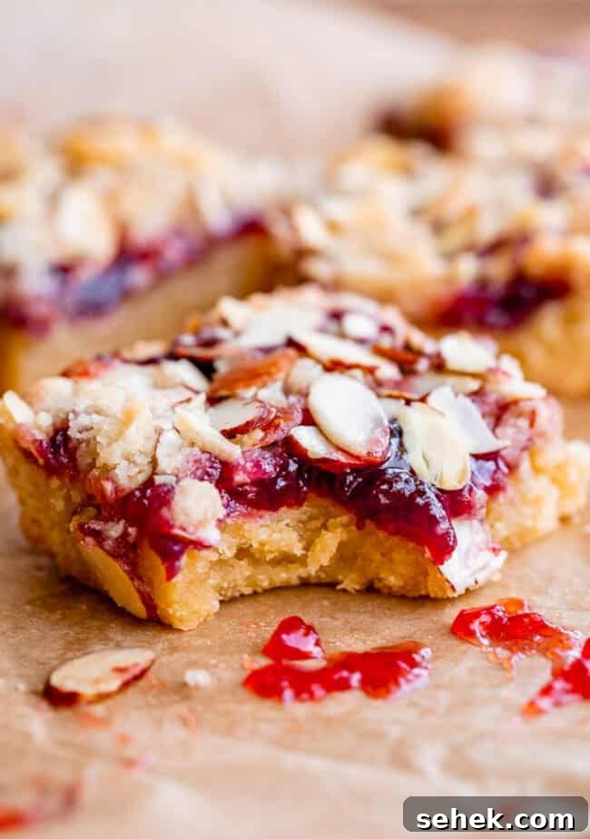 Raspberry Almond Streusel Crumble Bars 11 raspberry shortbread bar with jam with a bite taken.