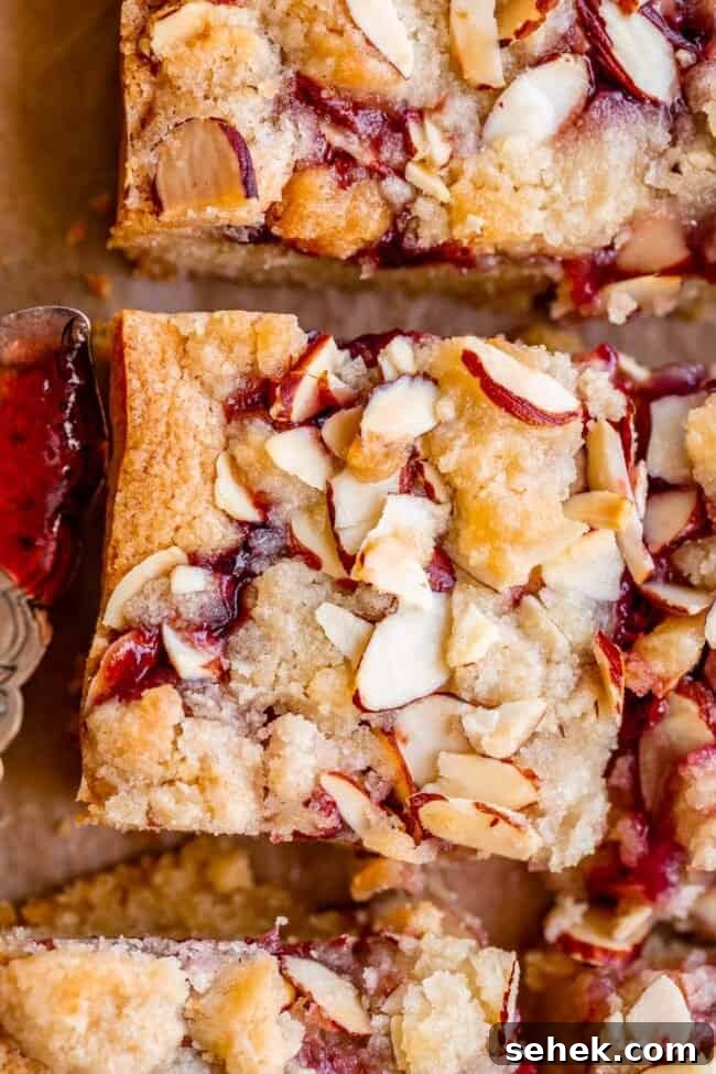 Raspberry Almond Streusel Crumble Bars 5 raspberry bars with sliced almond shot from overhead.