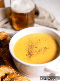 white bowl with beer cheese dip and sprinkle of paprika