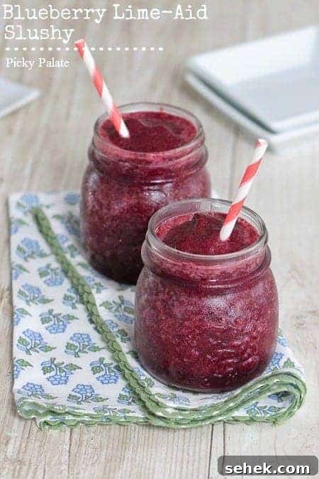 Essential Summer Drinks You Need This Season 2 Two blueberry limeade slushies side-by-side with straws.