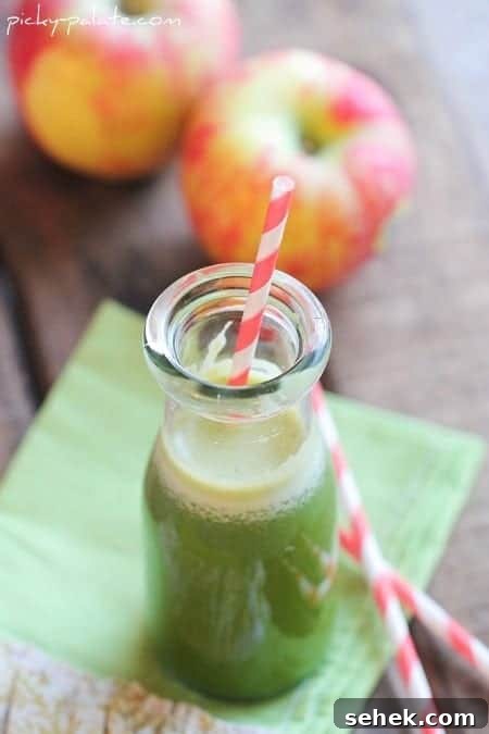 Essential Summer Drinks You Need This Season 6 Green juice in a glass with a red-striped straw, with apples in the background.