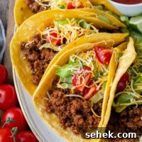 Weeknight Gluten-Free Tacos That Transform Dinner 11 a plate of ground beef tacos on a white plate with salsa in the background.