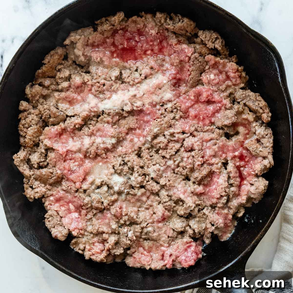 Weeknight Gluten-Free Tacos That Transform Dinner 4 ground beef in an iron skillet.
