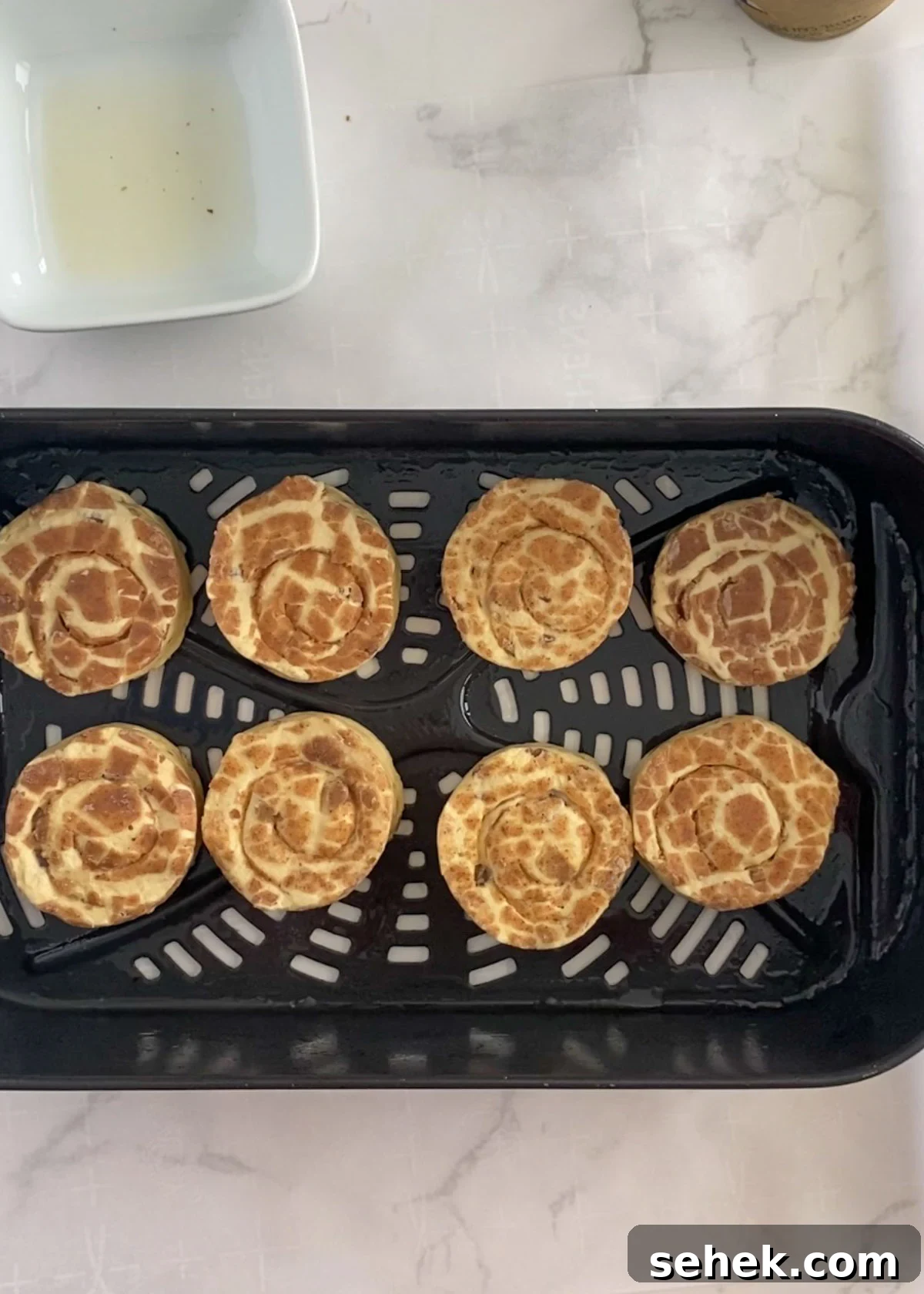 Air Fryer Pillsbury Cinnamon Rolls: Quick & Fluffy Recipe 5 raw cinnamon rolls in a greased air fryer basket.