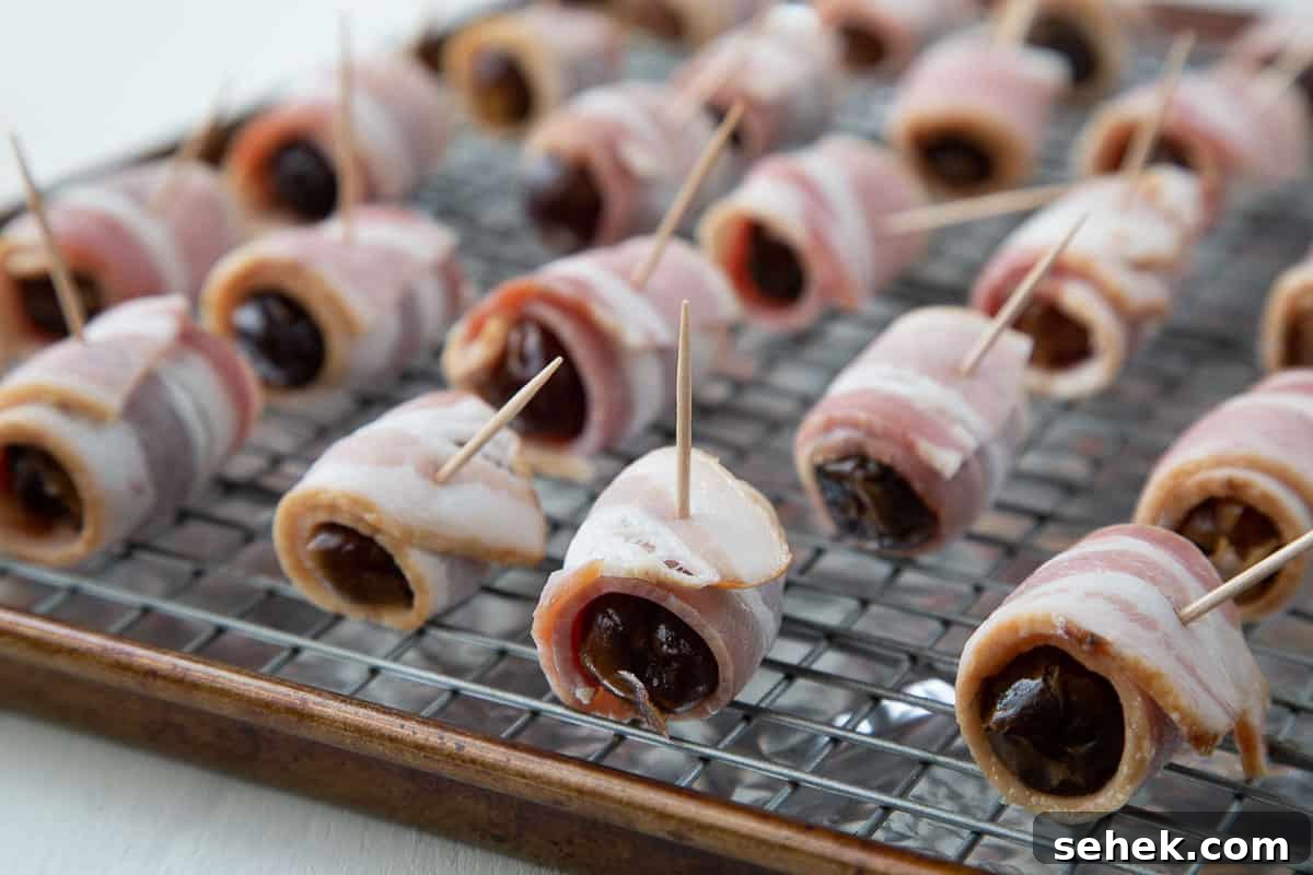 Bourbon Bacon-Wrapped Dates: Sweet, Savory Party Bites 4 uncooked bacon wrapped dates on a wire rack.