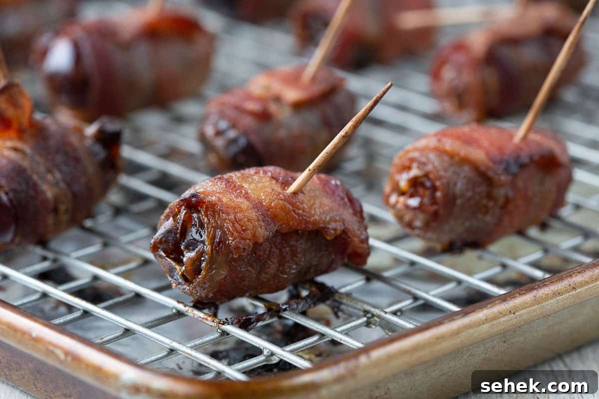 Bourbon Bacon-Wrapped Dates: Sweet, Savory Party Bites 5 crispy bacon wrapped dates on a wire rack.