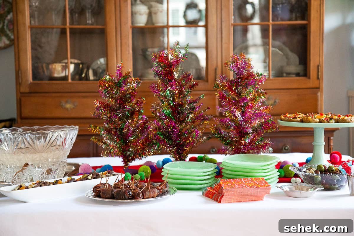 Bourbon Bacon-Wrapped Dates: Sweet, Savory Party Bites 6 table with assorted appetizers, green plates, a punch bowl, and colorful tabletop christmas trees.
