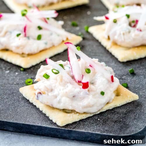 crab dip on saltine crackers on a black board