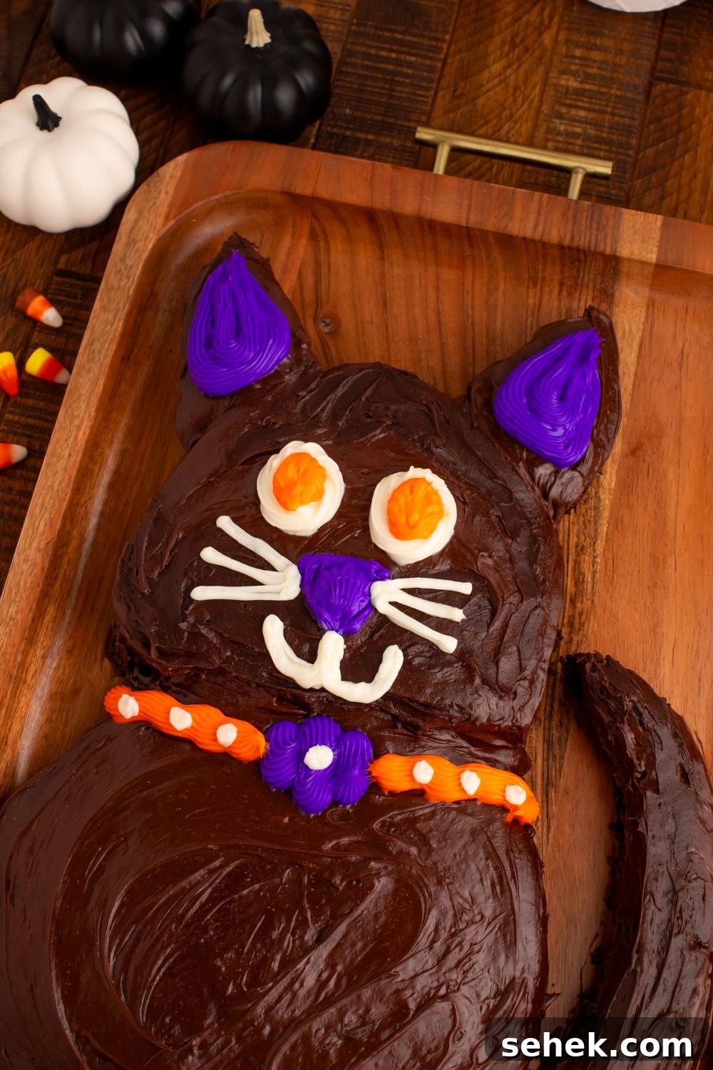 Easy Halloween Black Cat Cut Out Cake sitting on a wooden tray on table to show the Halloween cake