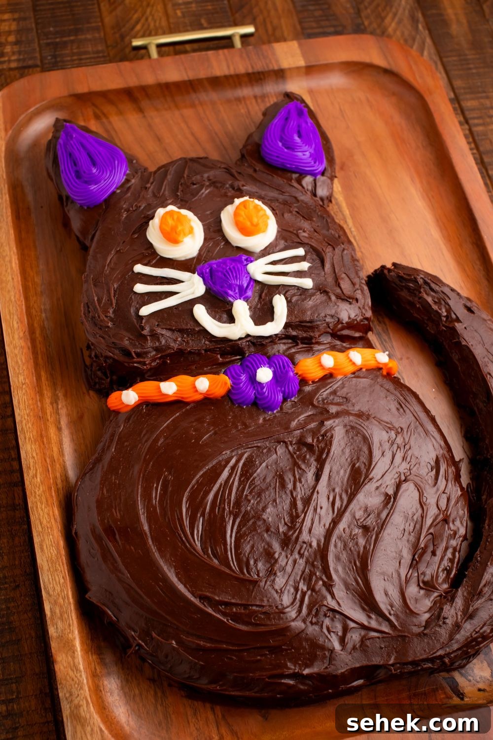 Homemade Halloween cake in the shape of a cat sitting on cutting board