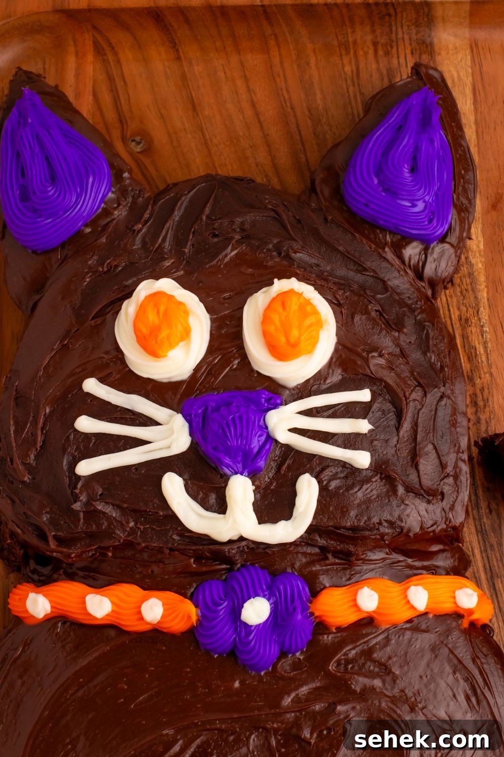close up of face of cat cake for Halloween on a wooden table tray 