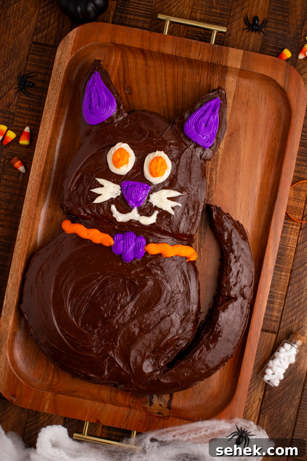 Easy Halloween Black Cat Cut Out Cake on a serving tray on table with some candy corn to the side 