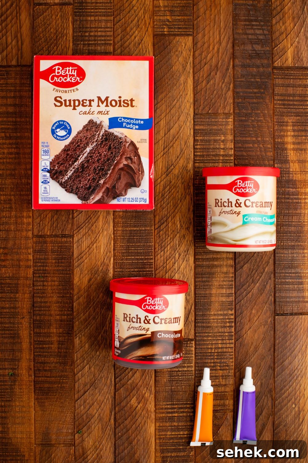 ingredients for making Easy Halloween Black Cat Cut Out Cake in containers sitting on the wooden table 