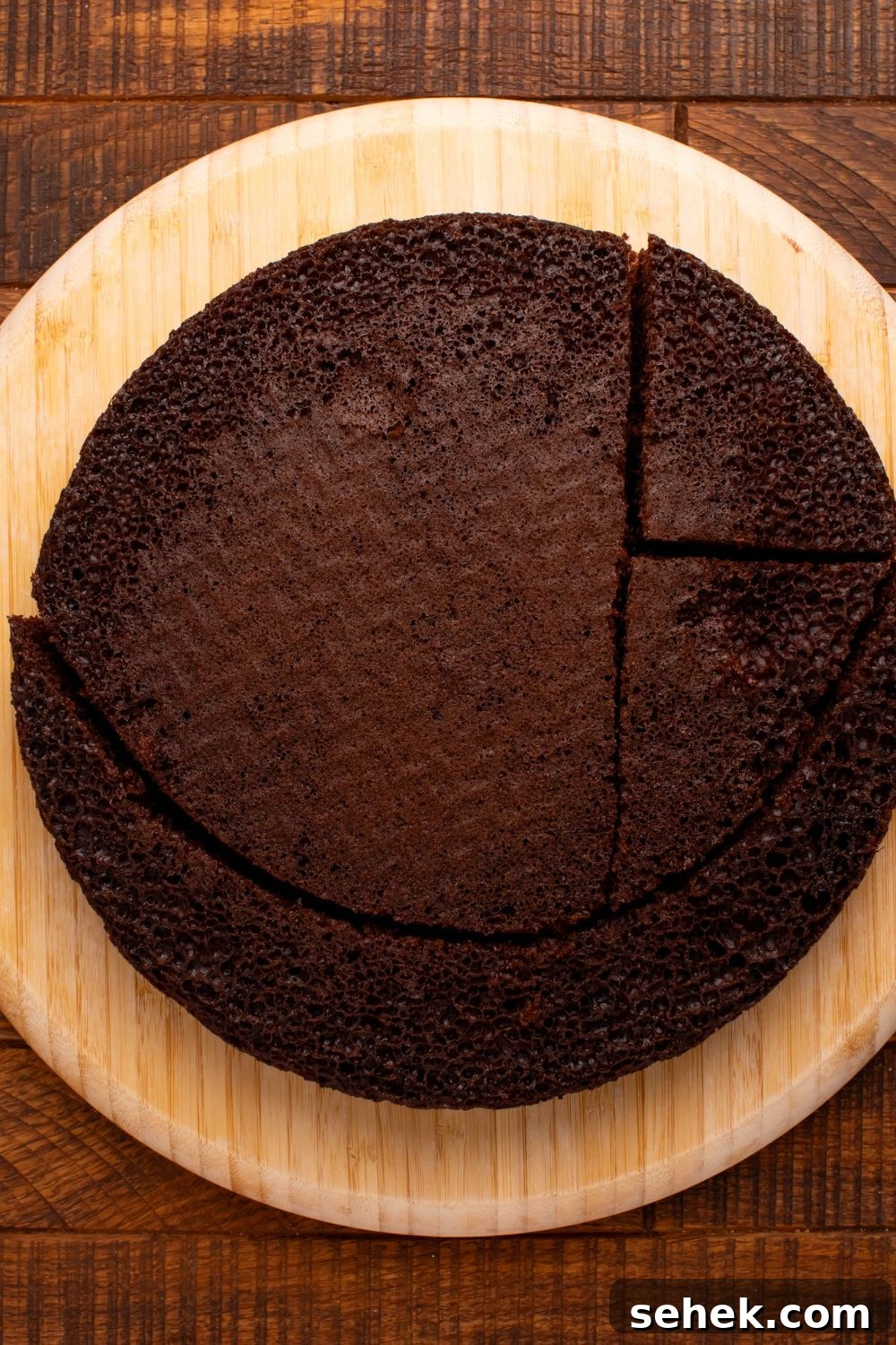 round cake being cut into pieces to shape into a cat 