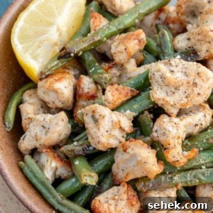 Crispy Lemon Pepper Chicken in the Air Fryer 12 air fryer lemon pepper chicken in a bowl with lemon wedge