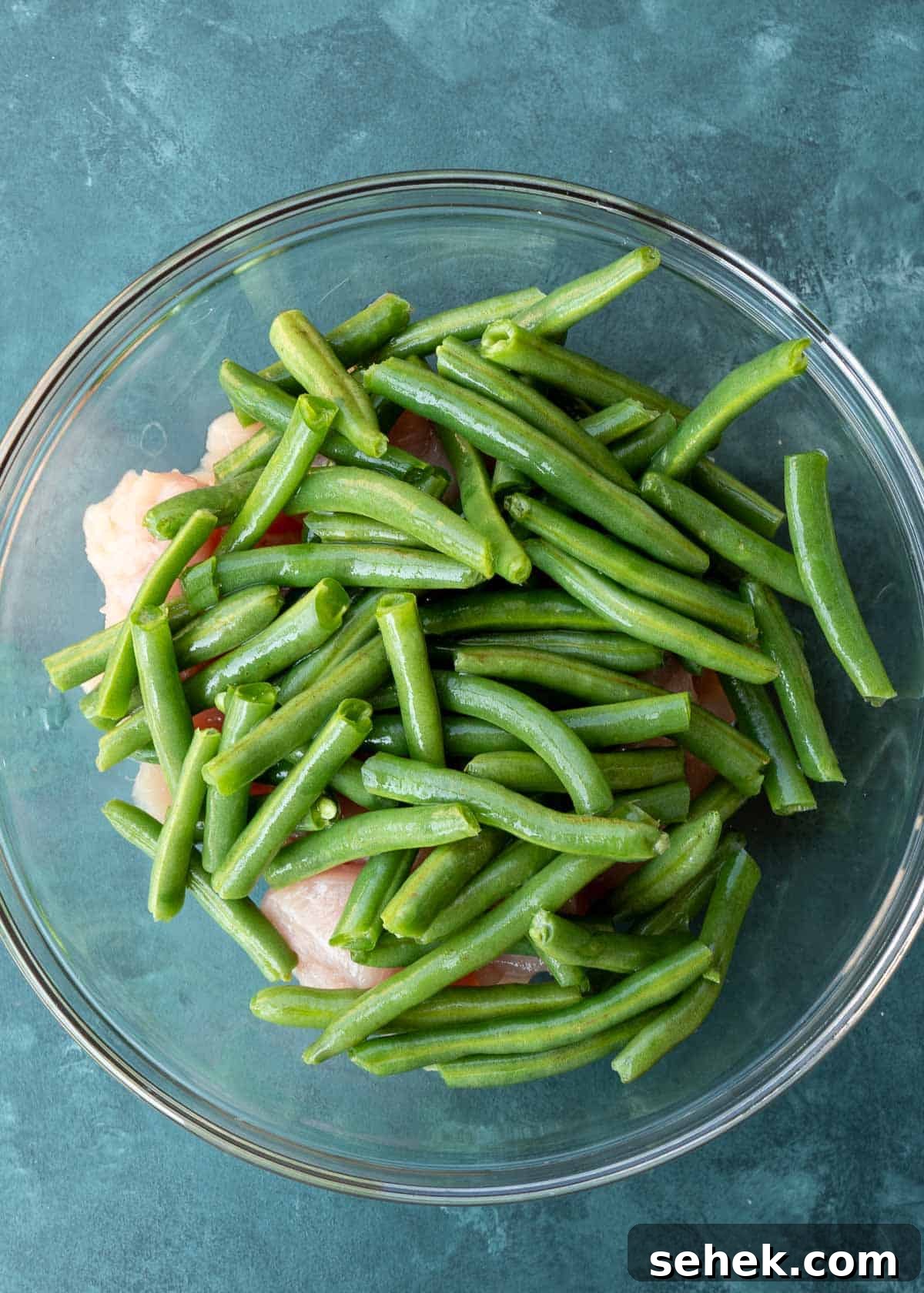 Crispy Lemon Pepper Chicken in the Air Fryer 4 green beans and chicken pieces in a glass bowl