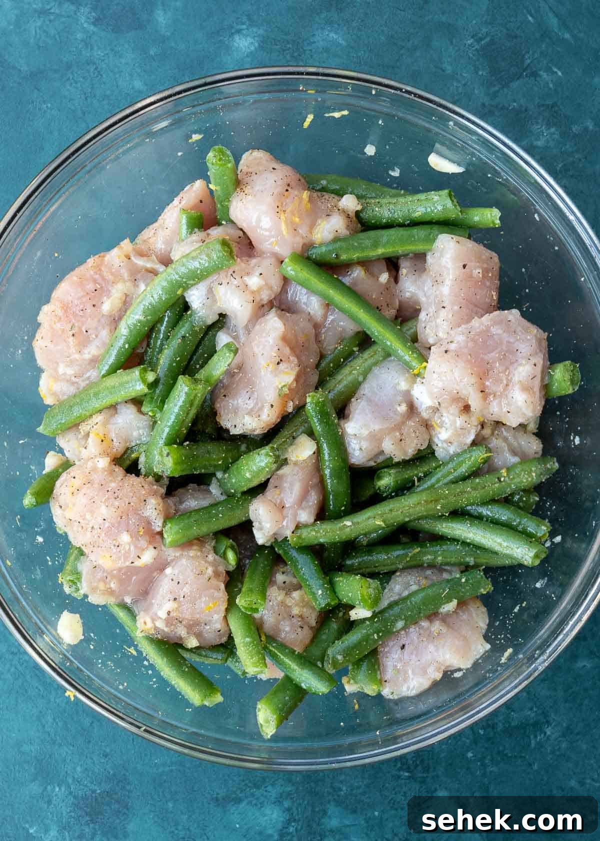 Crispy Lemon Pepper Chicken in the Air Fryer 6 seasoned chicken and green beans in a glass bowl