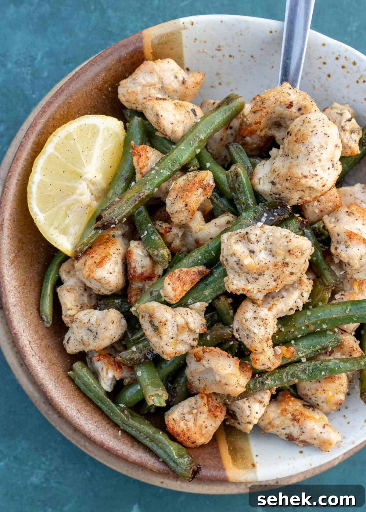 Crispy Lemon Pepper Chicken in the Air Fryer 8 lemon pepper chicken and green beans in a bowl after being air fried