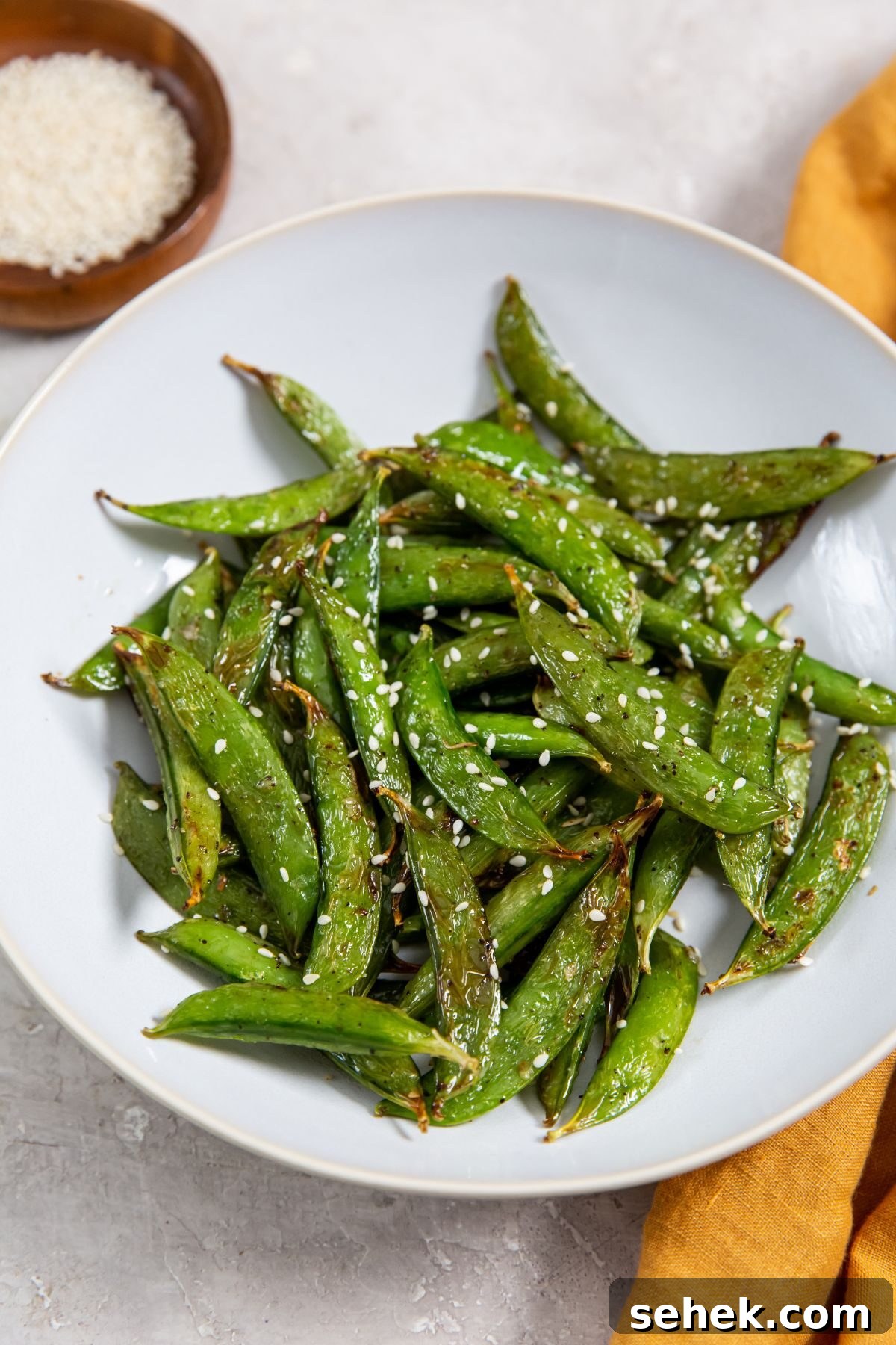 Crispy Air Fryer Sugar Snap Peas 2 Air Fryer Sugar Snapped Peas on a white plate with an orange napkin