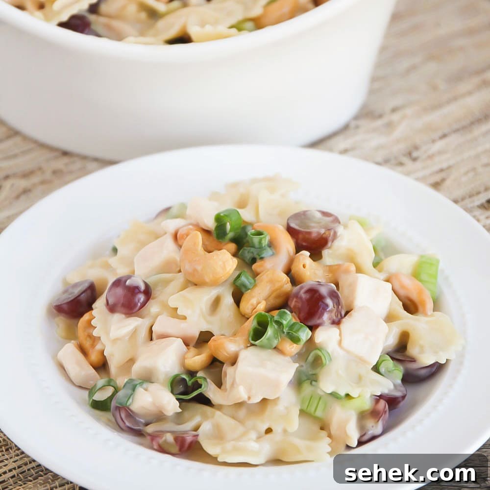 Creamy and fresh Cashew Chicken Salad is tossed in a delicious homemade dressing. It's a perfect summer salad! Cashew chicken salad on white plate.