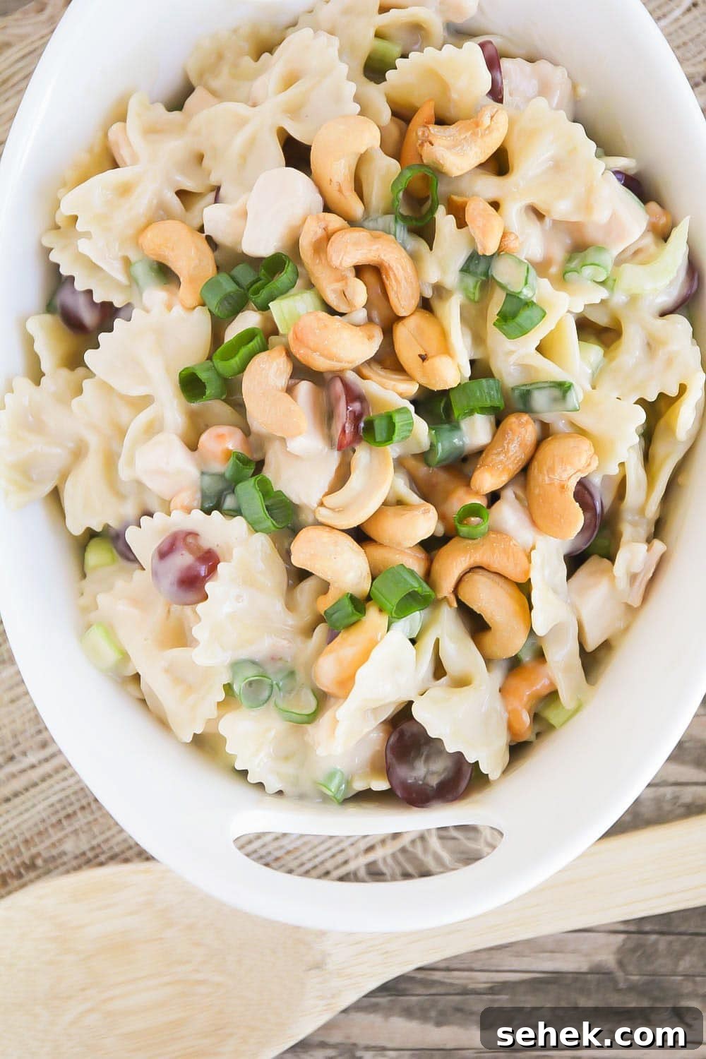 Creamy and fresh Cashew Chicken Salad is tossed in a delicious homemade dressing. It's a perfect summer salad! Cashew chicken salad recipe in white bowl.