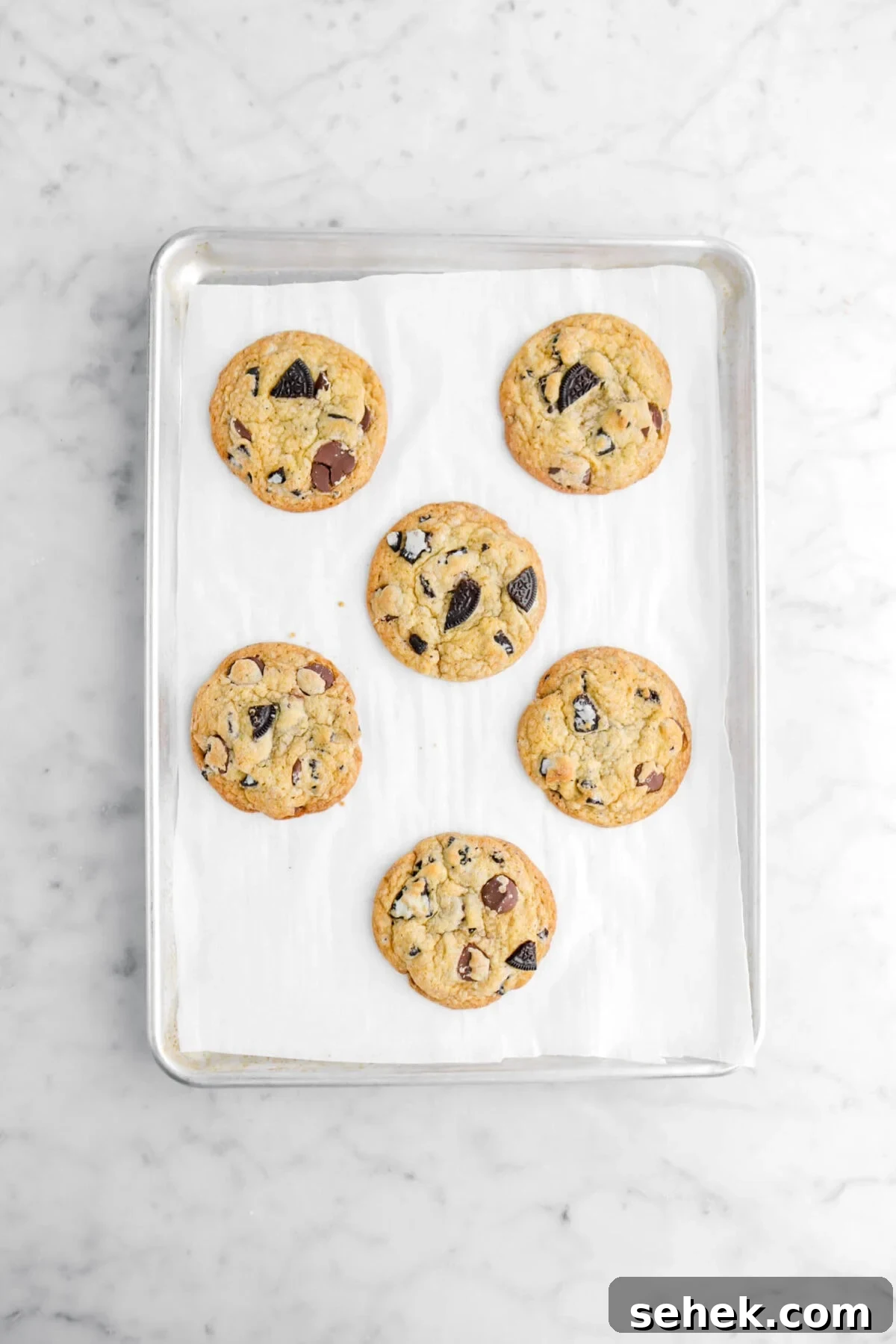 Oreo Chocolate Chip Cookies Recipe — Crispy Cookies with Oreo Chunks 9 six baked oreo chocolate chip cookies on lined sheet pan.