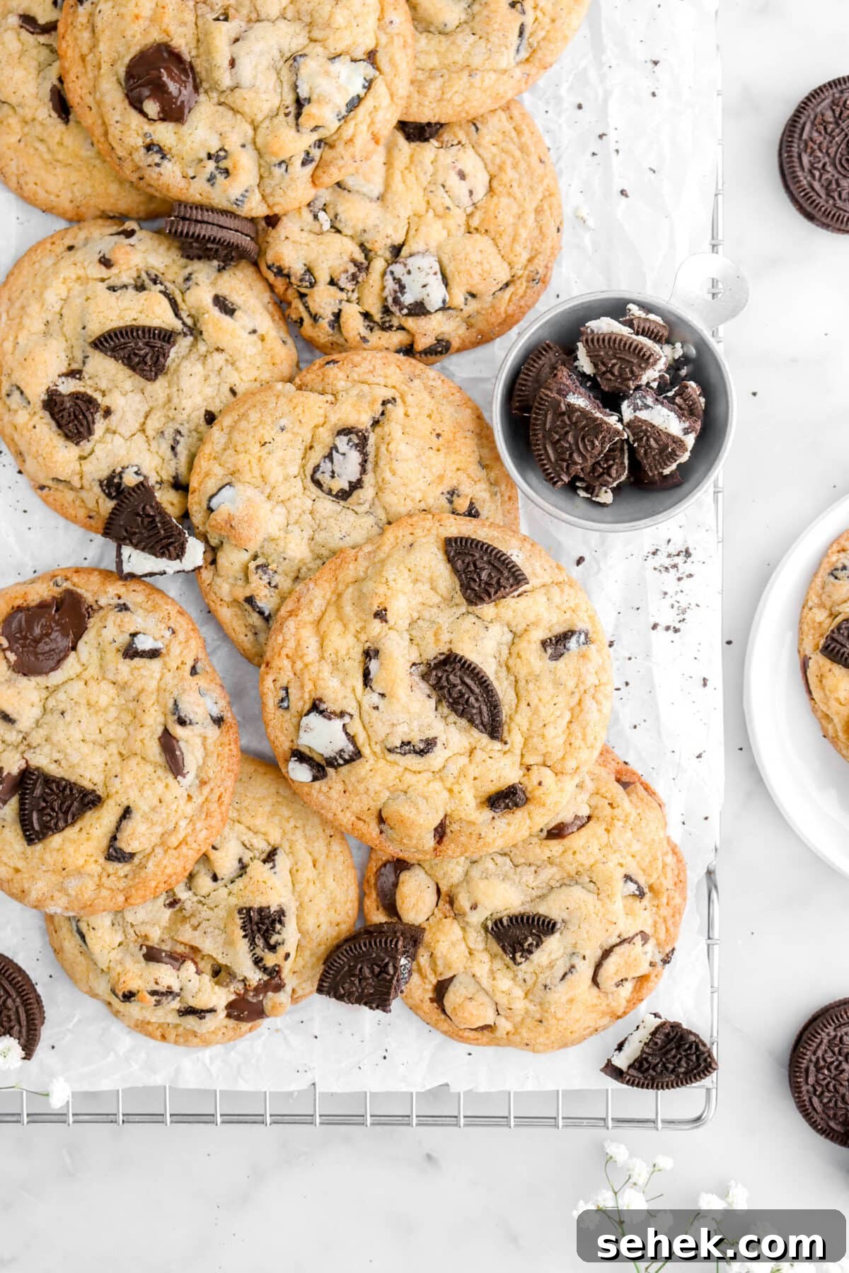 Oreo Chocolate Chip Cookies Recipe — Crispy Cookies with Oreo Chunks 11 cropped overhead shot of oreo chocolate chip cookies with measuring cup of chopped oreos beside.