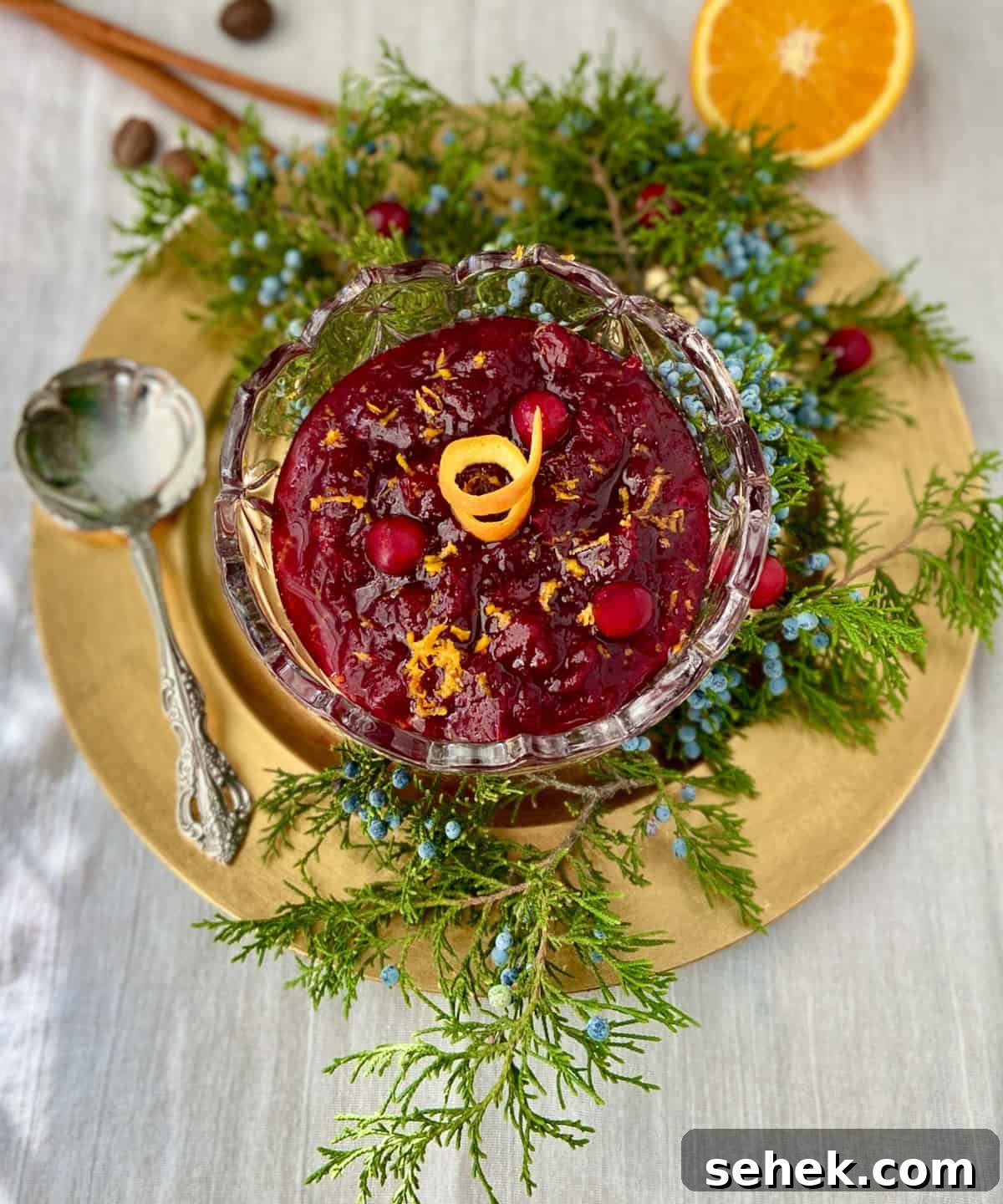 Homemade Spiced Cranberry Sauce with Warm Holiday Spices 2 Cranberry sauce in crystal bowl garnished with orange.