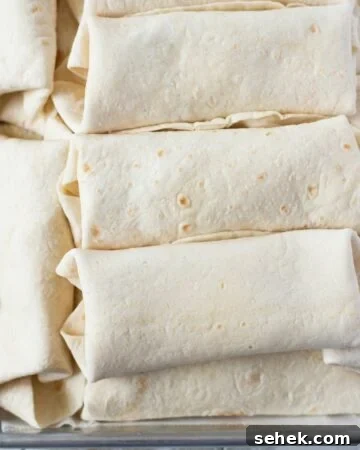 Breakfast Burritos stacked on a tray.