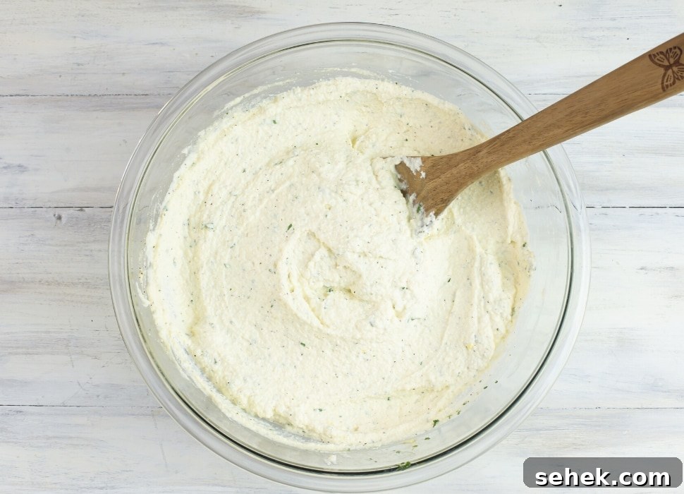 a glass bowl filled with ricotta filling for baked ziti