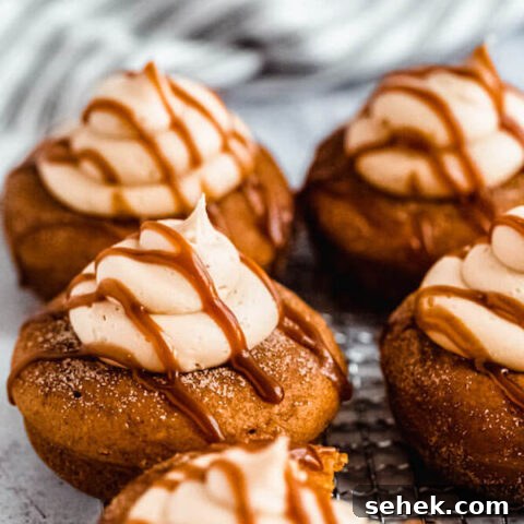 pumpkin donuts topped with salted caramel cream cheese frosting and salted caramel sauce drizzle on a safety grater