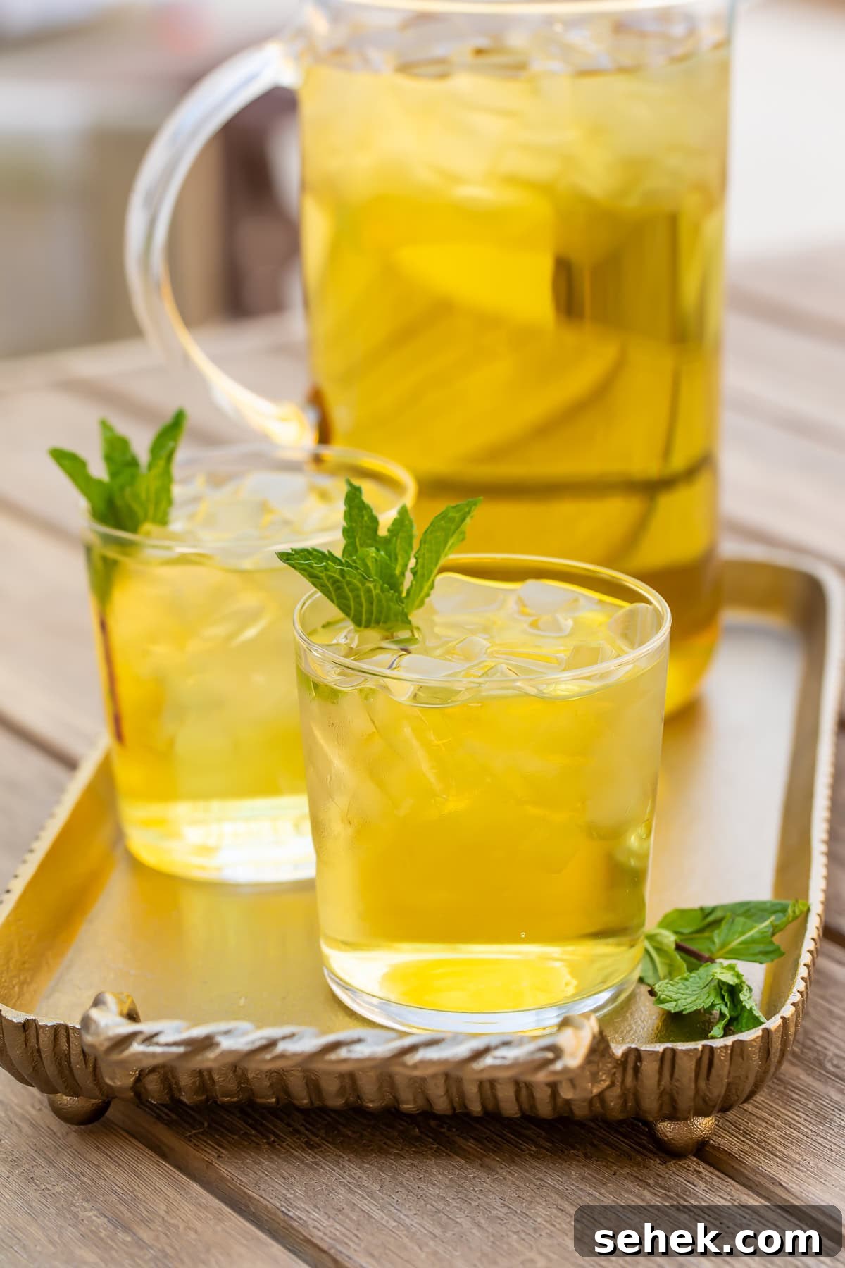 How to Make Refreshing Cold Brew Green Tea at Home 3 Two glasses of cold brew green tea in front of a pitcher on a table.