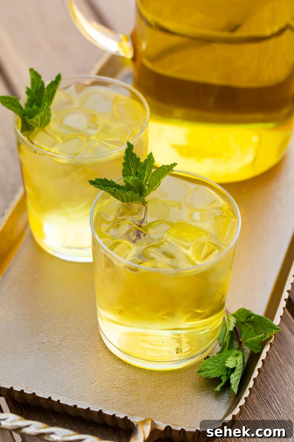 How to Make Refreshing Cold Brew Green Tea at Home 4 Two glasses of cold brew green tea in front of a pitcher on a table.