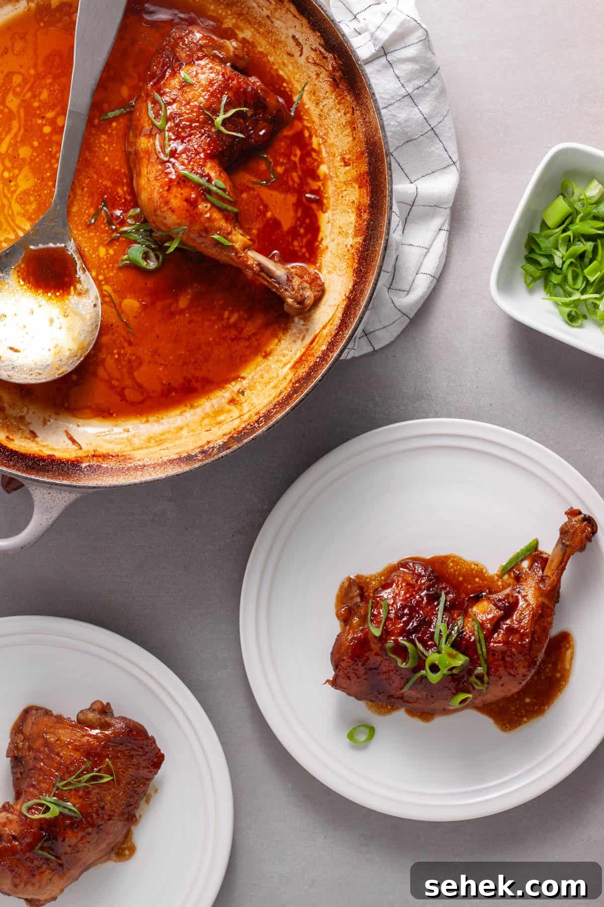 A pot of spicy chicken quarters with a citrus and soy sauce and two portions on plates. 